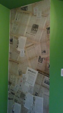 ściana pokryta gazetami z lat 60