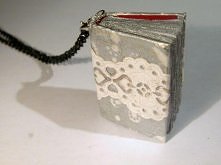 DELIKATNY SEKRETNIK POKREŚLONY PAPIEROWĄ KORONKĄ NA OKŁADCE. POSIADA DUŻO KARTEK W KOLORZE BIAŁYM, PO KTÓRYCH MOŻNA PISAĆ. KSIĄŻECZKA MA KARABIŃCZYK I DŁUGI ŁAŃCUSZEK.