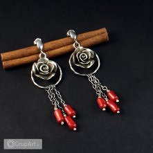 Oryginalne kolczyki - sztyfty wykonane ze srebra wałeczków korala robaczywki. Wyjątkową ozdobę stanowią srebrne róże o średnicy 17 mm zawieszone w kole o średnicy 2,2 cm. Długoś...