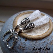 Długie, eleganckie, delikatne kolczyki wykonane z gładkich stożków polerowanego kwarcu lodowego, ubranych w zdobione, ażurowe, srebrne czapeczki. Kolczyki wykończone srebrnymi k...