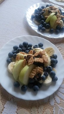 Banany na spodzie, następnie lody waniliowe, włożone do nich 2 plasterki jabłek, posypane borówkami, rodzynkami i skruszonym jednym sezamem.