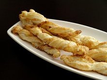 PIEKIELNE PALUSZKI Składniki: 2 płaty ciasta francuskiego 1 roztrzepane jajko ser żółty papryka ostra Wykonanie: 1 płat ciasta francuskiego lekko rozwałkować. Posmarować go rozm...