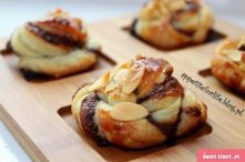 Składniki:

1 arkusz ciasta francuskiego
3 łyżki nutelli
3 łyżki mielonych orzechów laskowych
1 jajko
płatki migdałowe
brązowy cukier
Sposób przyrządzenia:

Schłodzone (ale rozm...