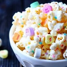 Najpierw zrobcie popcorn potem obleicie go rozpuszczona biala czekolada i posypcie posypka potem wsadzcie do zamrazarki na 2 min i posypcie cukierkami !