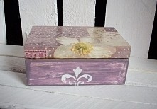 Drewniane, prostokątne pudełko na biżuterię i drobiazgi. Boki pudełka ręcznie malowane na kolor fioletowy z cieniami oraz dodatkowym białym wzorem szablonowym. Wieczko ozdobione...