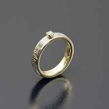 Pierścionek ze stali damasceńskiej i żółtego złota z brylantem o średnicy 2,75 mm
Inne Obrączki