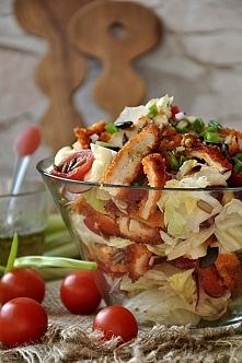 SKŁADNIKI na 4 porcje: 1 sałata lodowa 1 pierś z kurczaka 250 g pomidorków koktajlowych sól i pieprz do smaku pomidorki koktajlowe 1 czerwona cebula 1 jajko + 1 łyżka mleka płat...