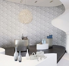 Nowoczesne wnętrze, wykończone delikatną, szarą tapetą. Tapeta pochodzi z kolekcji ONE SEVEN FIVE firmy ERISMANN