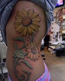 duże słoneczki tatuaże na żebrach