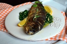 Pstrąg pieczony serwowany na szpinaku