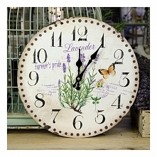 Piękny wiosenny zegar z krzaczkiem lawendy, motylkiem oraz w tle widoczne pieczątki przypominające kartkę pocztową.