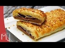 Składniki: - 1 rolka ciasta francuskiego - 1 tabliczka czekolady - 1 jajko - posiekane orzechy laskowe Wyłóż formę papierem do pieczenia. Rozwiń ciasto, a następnie na samym jeg...