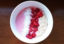 Smoothie Bowl: jogurt naturalny zmiksowany z truskawkami. Na wierzchu maliny, płatki owsiane i wiórki kokosowe