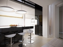 Czarna wyspa kuchenna przechodzi w czarny pas, stanowiący kontynuację dla sprzętu kuchennego.