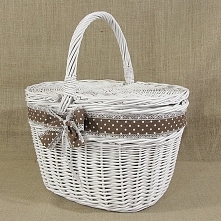 Biały wiklinowy kosz piknikowy zdobiony brązową wstążką w białe grochy