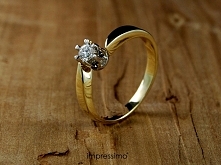 Pierścionek zaręczynowy Impressimo. Wykonany z żółtego złota. Zdobiony centralnie umieszczonym brylantem.