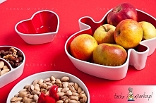 Fantazyjna miska na owoce w kształcie jabłka w biało-czerwonym kolorze.