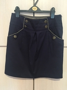 Lubisz granat? Jeżeli tak to ta spódnica jest idealna dla ciebie! Wykończona złotą nitką i z marynarskim guziczkami pięknie prezentuje się na każdej sylwetce. Plus jest straszni...