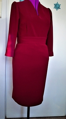 sukienka z ołówkową spódnicą rękawem 7/8 i delikatnie bufiastymi rękawami i dekoltem w kształcie pęknięcia, lekko nachodzący na szyję