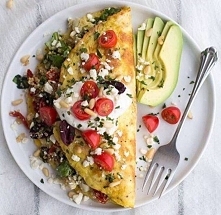 Składniki:
• 4 jajka
• 50 ml mleka roślinnego
• garść młodych listków szpinaku
• 1 cebulka
• pomidorki koktajlowe
• orzechy pinii
• ser feta pokruszony
• 1 awokado
• olej kokoso...