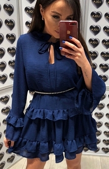 Lola Fashion Spanish granatowa Przepiękna sukienka typu oversize wykonana została z lekkiego materiału, model posiada luźny krój ozdobiony falbankami, przy dekolcie wiązanie