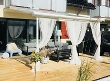 Białe stylowe zadaszenie tarasu marki solidnej marki Palram. 
Pięknie prezentuje się na nowoczesnych tarasach.