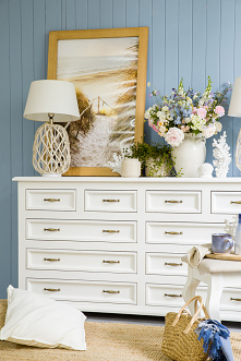 Biała duża komoda drewniana z szufladami do sypialni.