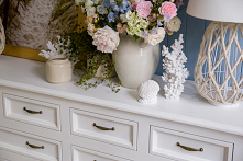 Biała duża komoda drewniana z szufladami do sypialni.