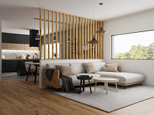 Nowoczesny salon przedzielony od kuchni stołem jadalnianym.