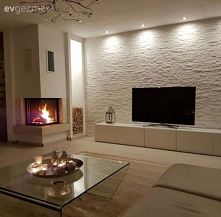 Dywan, stolik kawowy, salon, kominek, kamienna ściana, telewizor W domu pani Seval mieszkającej w Niemczech, gdzie panuje prosta i elegancka atmosfera, kamienna ściana i kominek...