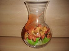 Wazon w środku kwiaty i piórka .Na zewnątrz ozdobne liście przyklejone wikolem