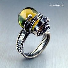 Okazały pierścionek srebrny z kwarcem bi-colour klasy AAA (odcień żółto-zielony). Wykonany techniką wire-wrapping, oksydowany i polerowany. Regulowany: wielkość od 17 do 23 (śre...