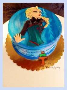 Tort z malowaną Elsą śpiewającą "Mam tę moc"