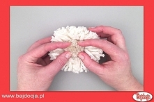 Usuń wełnę użytą do związania dużego pomponu. Utwórz wgłębienie w środku jego włochatej części i wlej do środka klej. Następnie przyciśnij do niego mały pompon, by przytwierdzić...