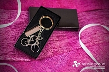 Brelok do kluczy w kształcie rowerzysty przymocowany jest do kółka na klucze za pomocą srebrnego łańcuszka. Do kółka przytwierdzona jest również metalowa plakietka która umożliw...