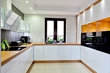 Założeniem projektu była ponadczasowa biała kuchnia. Surowości nadaje polerowany beton na ścianie oraz białe cegły przy oknie.