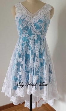 Sukienka o rozkloszowanym i asymetrycznym kroju. Uszyta z satyny grubej i koronki koder/gipiury. Odcinana w talii.