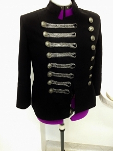 Żakiet ze stójką z ozdobnymi guzikami i wstążką.