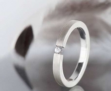 Srebrny pierścionek o minimalistycznej formie, wykorzystujący dość nietypowy typ oprawy, polegający na ściskaniu z dużą siłą kamienia umieszczonego między końcami szyny. Oprawio...