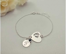 Bransoletka serce z wyciętymi laserowo stópkami, wykonana z delikatnego łańcuszka. Ozdobiona jedną zawieszką z wygrawerowaną literą, oraz małym kamieniem naturalnym Szafiru.

Ca...