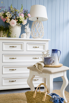 Biała duża komoda drewniana z szufladami do sypialni.