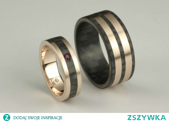 Obrączka z różowego złota z paskiem carbonu przez środek o szerokości 5 mm i oprawionym rubinem o średnicy 1,9 mm. Druga obrączka to realizacja z carbonu z dwoma paskami różowego złota i szerokości 8 mm. Obrączki mają wykończenie satynowane.